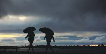  ?? K.C. ALFRED ARCHIVO U-T ?? Personas caminan bajo una ligera lluvia cuando una tormenta se adentró en la zona en Nov. 7 de 2022.