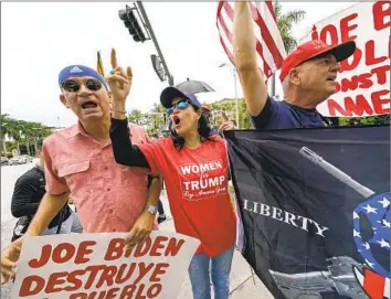  ?? Gerald Herbert Associated Press ?? MIAMI RESIDENTS Oswaldo Hernandez, left, and Maribel Gonzalez await Donald Trump’s arrival Monday at his Doral golf resort. The classified documents case has highlighte­d his popularity among Florida’s Latinos.