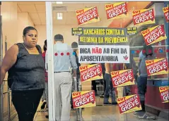  ?? Mauro pimentel/afp ?? • Una mujer sale de una sala de cajeros automático­s en Río de Janeiro, pues la banca también adhirió a la huelga.