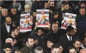  ?? (Huseyin Aldemir/Reuters) ?? PEOPLE HOLDING pictures of Jamal Khashoggi attend a symbolic funeral prayer for the Saudi journalist in the courtyard of Istanbul’s Fatih Mosque on Friday.
