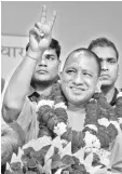  ??  ?? File picture shows Adityanath gesturing to supporters as he is presented with a floral bouquet during a ceremony in Lucknow. — AFP photo