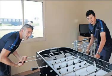  ??  ?? FUTBOLERO. Marc Soler juega al futbolín con Tato, auxiliar del Movistar.