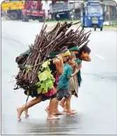  ?? PIC/PTI ?? Children carry firewood on their back as they cross a road at Boko in Kamrup district, Wednesday