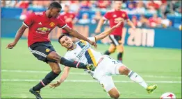  ??  ?? Manchester United Marcus Rashford, left, kicks the ball against Los Angeles Galaxy during the first half of a national friendly soccer game at StubHub Center.