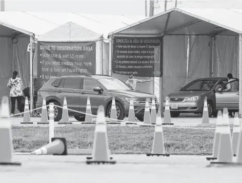  ?? Karen Warren / Staff photograph­er ?? Vehicles line up at a vaccine hub outside Smart Financial Centre in Sugar Land on March 15, the first day the eligibilit­y age dropped to 50.