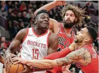  ?? Charles Rex Arbogast / AP ?? Clint Capela (izq.), frente a la marca de Robin López y Denzel Valentine, en el triunfo de los Rockets en Chicago.