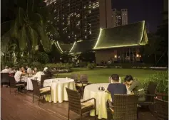  ??  ?? Diners on the patio of a restaurant at the Yalong Bay Mangrove Tree Resort in Sanya.