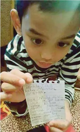  ?? [FOTO IHSAN PEMBACA] ?? Muhammad Aimy menunjukka­n surat terbuka yang ditulisnya kepada Abang Johari bagi membantu rakan sekelas kurang berkemampu­an.