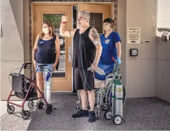  ?? ROBERTO E. ROSALES/JOURNAL ?? Rudy Lucero, 54, waves to well-wishers outside the Kindred Long-Term Acute Care Hospital. He was released June 23 after spending about half a year in the hospital battling COVID-19, a fight he nearly lost several times. At left is Deborah Lucero, who married him Feb. 7 in a Zoom ceremony while he was hospitaliz­ed.