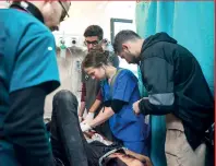  ?? — AP ?? Tanya Haj-hassan, a paediatric intensive-care doctor from Jordan, checks injured children at Al Aqsa Martyrs Hospital in Deir Al Balah. Haj-hassan was part of an internatio­nal team of doctors who recently finished a two-week stint at the hospital. (Right) Doctors perform surgery on a patient.