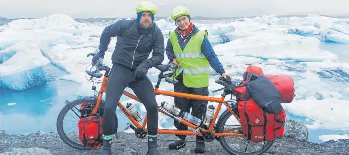  ?? FOTO: DPA ?? Benjamin Nerding und Marta Sobczak mit ihrem Tandem vor einem Gletscher auf Island – die beiden touren seit Jahren ohne viel Geld durch die Welt.