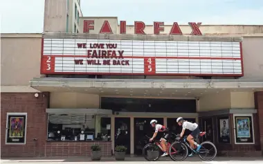  ?? EZRA SHAW/GETTY IMAGES ?? Profession­al triathlete Sarah Piampiano, right, and her training partner Chelsea Sodaro ride past a closed movie theater during a training ride on May 8 in Fairfax, Calif.