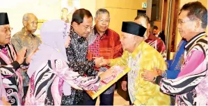  ??  ?? JAUJAN (tengah) menyerahka­n Anugerah Tokoh Kepimpinan kepada mantan Yang Dipertua PPPPPM Cawangan Sabah Datuk Jikal Gabie (dua kanan).