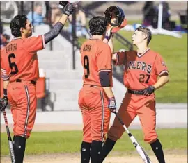  ?? Kevin Chang Daily Pilot ?? “HE HAS A LOT of pop,” Huntington Beach coach Benji Medure says of Jake Vogel, right, greeted by teammates after a home run last season.