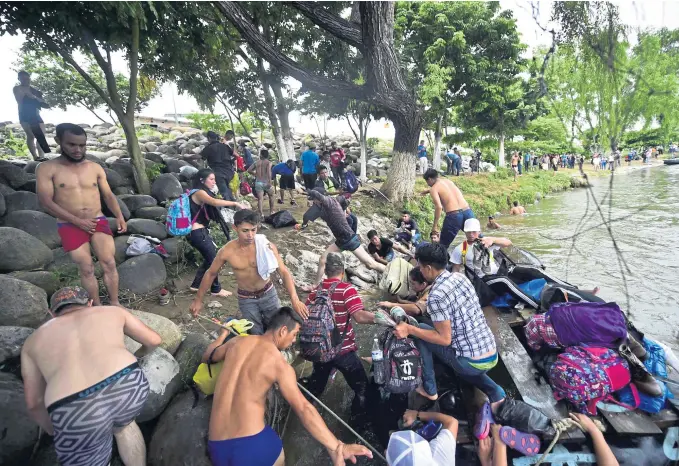  ?? PEDRO PARDO / AFP / VIA AP ?? RIVER CROSSING: Honduran migrants heading in a caravan to the U.S., arrive in Ciudad Hidalgo, Chiapas state, Mexico after crossing the Suchiate River from Guatemala in makeshift rafts yesterday.