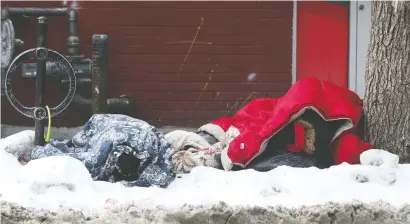  ?? TONY CALDWELL FILES ?? Two homeless people try to stay warm under sleeping bags on George Street in Ottawa last week.