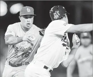  ?? Photog r aphs by Wally Skalij Los Angeles Times ?? ST. LOUIS second baseman Kolten Wong tags Zack Greinke with his glove during a third- inning rundown. Greinke was ruled safe after a replay review because the ball was in Wong’s other hand.