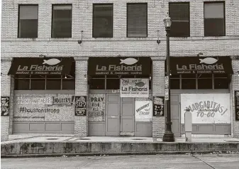  ?? Photos by Yi-Chin Lee / Staff photograph­er ?? La Fisheria has boarded up its windows with positive messages while still providing to-go service. More than 254,000 people filed for first-time unemployme­nt benefits in Texas last week.