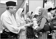  ??  ?? Awang Tengah and wife Dayang Morliah greet guests at the Raya gathering.