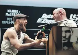  ?? Isaac Brekken Getty Images ?? CONOR McGREGOR, left, shares a playful moment with UFC President Dana White during a news conference for Saturday night’s title match in Las Vegas.