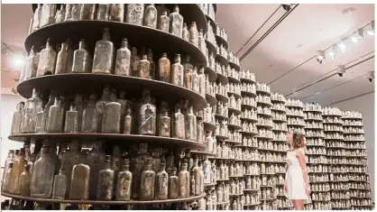  ?? — Photos: National Gallery Singapore ?? Thai artist Navin Rawanchaik­ul’s Asking For Nothingnes­s comprises 11,000 old medicine bottles – half filled with black-and-white photograph­s of elderly villagers.