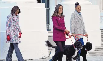  ?? SUSAN WALSH/ASSOCIATED PRESS ?? Michelle Obama, in happy times with her daughters and their dogs, takes a walk outside the White House in 2014. Obama has experience­d depression and anxiety during the coronaviru­s pandemic.