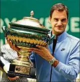  ??  ?? Immer noch der König von Halle: Roger Federer präsentier­t die Trophäe. Foto: dpa