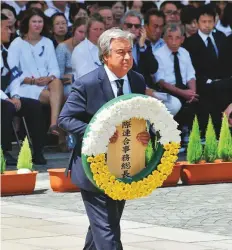  ?? AFP ?? UN Secretary-General Antonio Guterres carries a wreath of flowers to the altar during a memorial ceremony to mark the 73rd anniversar­y of the atomic bombing at the Peace