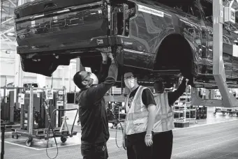  ?? Brittany Greeson/New York Times ?? A 2022 Ford F-150 Lightning pickup, an electric model, is checked at a manufactur­er in Dearborn, Mich. Ford sold 15,300 electric cars from April through June.