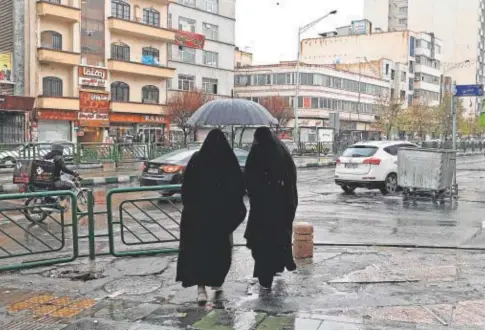  ?? // AFP ?? Dos mujeres con chador caminan por la plaza Enghelab, en Teherán