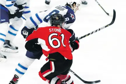  ?? FRED CHARTRAND/THE CANADIAN PRESS ?? Ottawa Senators forward Mark Stone is hit by Winnipeg Jets defenceman Jacob Trouba Sunday during the Jets’ 3-2 win in Ottawa. Stone left the game with a suspected concussion, while Trouba was given a two-minute minor for an illegal check to the head.