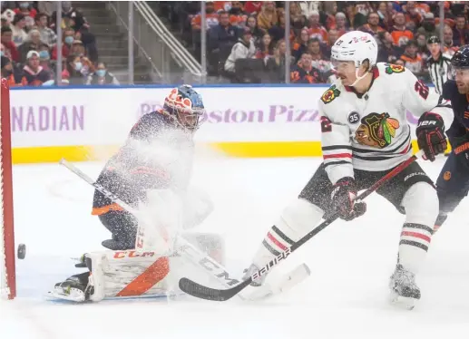  ?? JASON FRANSON/AP ?? Oilers goalie Stuart Skinner is the victim of a snow shower after stopping a shot by the Hawks’ Ryan Carpenter in the first period Saturday.