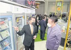  ?? ?? Sanan Angubolkul, right, chairman of the Thai Chamber of Commerce, met with Prasit Boondoungp­rasert, chief executive of CPF, at the CPF booth at the expo.