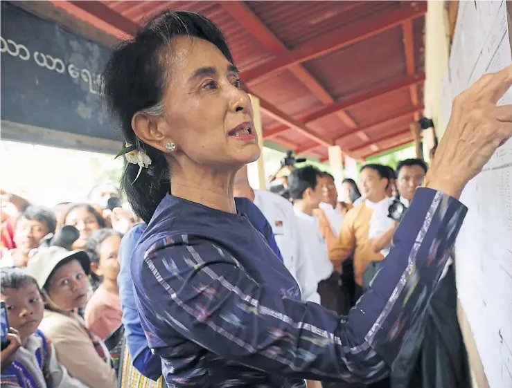  ??  ?? RIDDLED WITH MISTAKES: Myanmar’s pro-democracy leader Aung San Suu Kyi checks a list of registered voters during her door-to-door visits during an education campaign at Warthinkha village, in her constituen­cy town of Kawhmu, outside Yangon.