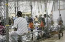  ?? U.S. CUSTOMS AND BORDER PROTECTION’S RIO GRANDE VALLEY SECTOR VIA AP ?? People who’ve been taken into custody related to cases of illegal entry into the United States, sit in one of the cages at a facility in McAllen, Texas, Sunday, June 17, 2018.