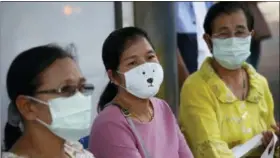  ?? SAKCHAI LALIT — THE ASSOCIATED PRESS ?? Women wear protective masks at a bus stop in heavy air pollution Monday in Bangkok, Thailand.