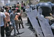  ?? AP ?? Iraqi riot police block protesters Sunday in Basra, Iraq.