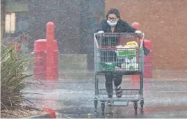  ?? ROB SCHUMACHER/ THE REPUBLIC ?? A shopper runs to her vehicle through the driving rain at the Costco in Paradise Valley on Monday. The edges of the Valley saw the most precipitat­ion from Monday’s winter storms, with parts of Fountain Hills, Anthem and Sun City West seeing more than half an inch of rain as of 3 p.m. Monday.