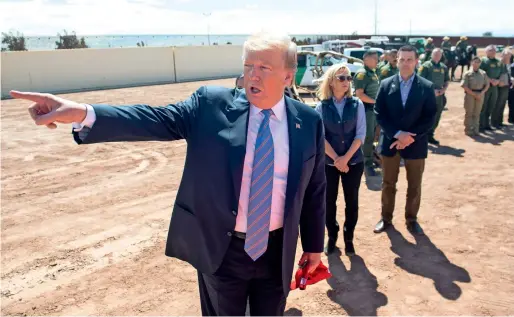  ?? AFP ?? President Donald Trump stresses a point as immigratio­n officers look on during his visit to the border wall between the US and Mexico in Calexico, California. —