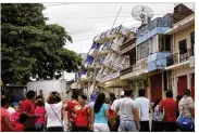  ?? FELIX MARQUEZ / ASSOCIATED PRESS ?? Residents look at a partially collapsed hotel in Matias Romero, Oaxaca state, Mexico, on Friday. A powerful earthquake Thursday night sent many frantic people into the streets.