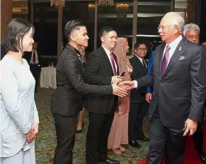  ??  ?? Warm welcome: Najib being greeted by volunteer ushers at the United Nations Associatio­n of Malaysia dinner.