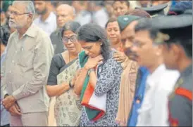  ?? PHOTOS: SATYABRATA TRIPATHY ?? Major Kaustubh Rane's wife, holding the tricolour used to cover his body, at his funeral at Mira Road on Thursday.