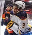  ?? The Canadian Press ?? Buffalo Sabres left wing Evander Kane (9) is checked by Edmonton Oilers defenceman Adam Larsson during third-period NHL action Tuesday in Edmonton.