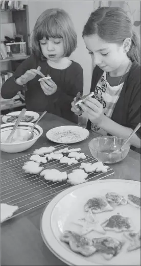  ?? ALLEN MCINNIS/ THE GAZETTE ?? Iona Riga, right, 10, and her sister Sabina, 6, make wheat and dairy-free Christmas cookies.