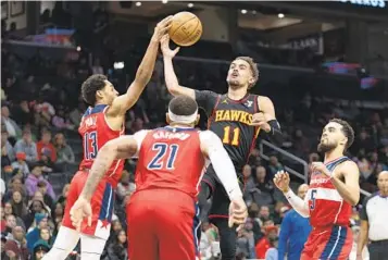  ?? NBA REPORT JOSE LUIS MAGANA AP ?? Hawks’ Trae Young (11), who scored 40 points, fights for the ball with Wizards’ Jordan Poole on Sunday.