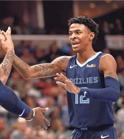  ?? JOE RONDONE/THE COMMERCIAL APPEAL ?? Grizzlies guard Ja Morant, right, high-fives teammates Brandon Clarke and Jae Crowder during their game against the Rockets Nov. 4, 2019 at the Fedexforum in Memphis, Tenn.