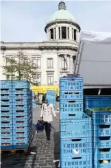  ?? — AFP ?? BRUSSELS: A woman walks past a market in Molenbeek’s main square, in Brussels. One year on from the Paris massacres, the gritty district in Brussels that was the launchpad for the attacks is struggling to shed its reputation as a jihadist hotbed.