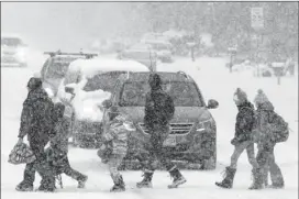  ?? BRENNAN LINSLEY / AP ?? Students in Boulder, Colo., some escorted by parents, cross a snowy street en route to school Wednesday as a blizzard dumps more than a foot of snow.