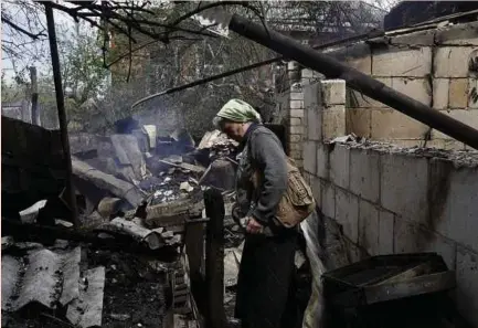  ?? (Foto REUTERS) ?? Penduduk melihat kesan kerosakan rumah yang dibedil tentera Russia di perkampung­an Berzuky di daerah Derhachi, wilayah Kharkiv, Ukraine.