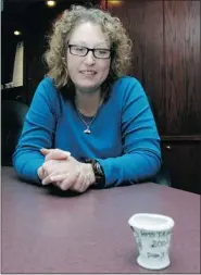  ?? BRYAN SCHLOSSER/LEADER-POST ?? Lori Johnston-hill looks at a styrofoam cup she attached outside the submersibl­e that took her to the Titanic site.